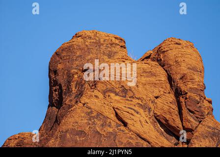 Overton, Nevada, USA - 11. Dezember 2010: Valley of Fire. Nahaufnahme eines rotbraunen verschleierten Kopfes, der unter blauem Himmel zusammengehalten wird. Stockfoto