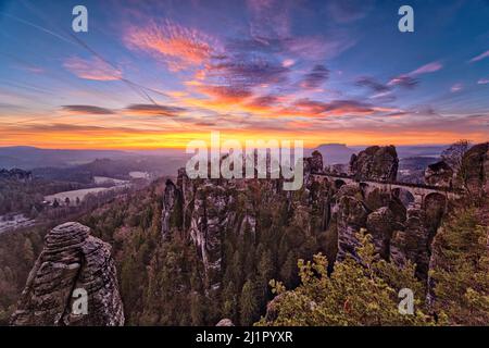 Landschaft mit den Felsformationen Felsenburg Neurathen und Bastei im Rathen-Gebiet des Nationalparks Sächsische Schweiz bei Sonnenaufgang. Stockfoto