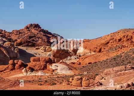 Overton, Nevada, USA - 11. Dezember 2010: Valley of Fire. Landschaft von intensiven roten felsigen Berg durch ein paar hellgraue Flecken unter blauem Himmel versetzt. Stockfoto