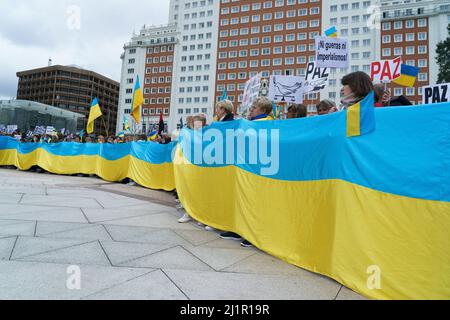 Madrid, Spanien. 27. März 2022. Demonstranten halten ukrainische Flaggen und Plakate während einer Kundgebung gegen die russische Invasion in die Ukraine. Tausende von pro-ukrainischen Demonstranten demonstrieren gegen die russische Invasion, während sie sich von der Plaza de Espana (spanischer Platz) zur Plaza de Callao in Madrid, Spanien, versammeln. Kredit: SOPA Images Limited/Alamy Live Nachrichten Stockfoto