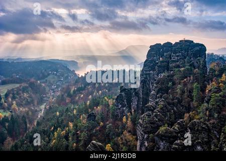 Landschaft mit Felsformationen, dem Gipfel Hintere Gans und bunten Bäumen im Herbst im Rathen-Gebiet des Nationalparks Sächsische Schweiz. Stockfoto