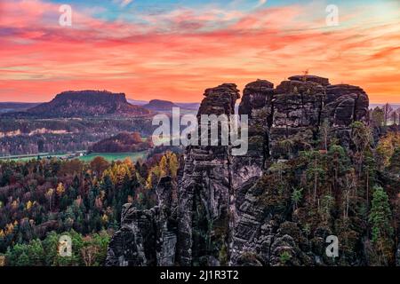 Landschaft mit Felsformationen, die Gipfel Hintere Gans und Lilienstein im Rathen-Gebiet des Nationalparks Sächsische Schweiz bei Sonnenuntergang im Herbst. Stockfoto