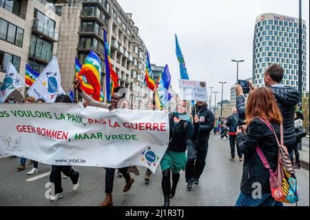 Brüssel, Belgien. 27. März 2022. Eine Gruppe von Demonstranten, die ein Banner mit sich führen, das während der Demonstration auf der Straße gelaufen ist. Zahlreiche belgische Gewerkschaften und zivile Organisationen organisierten unter dem Namen „Europa für den Frieden“ eine Kundgebung, um den russischen Einmarsch in die Ukraine zu verurteilen. Tausende von Menschen versammelten sich am Nordbahnhof, um einen Waffenstillstand und eine Deeskalation der Invasion Putins in die Ukraine zu fordern. Die Menschen wollen auch ihre Solidarität mit allen Flüchtlingen zeigen. Kredit: SOPA Images Limited/Alamy Live Nachrichten Stockfoto