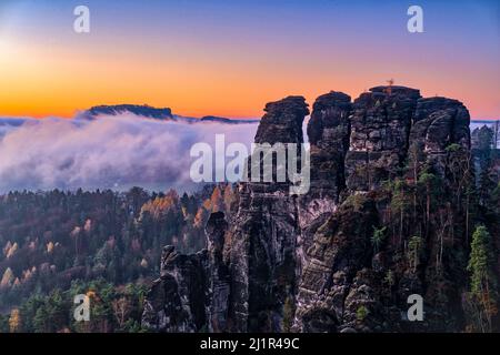 Landschaft mit Felsformationen, die Gipfel Hintere Gans und Lilienstein im Rathen-Gebiet des Nationalparks Sächsische Schweiz bei Sonnenaufgang im Herbst. Stockfoto