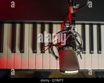 Nahaufnahme. Musikinstrument - MIDI-Tastatur und Mikrofon. Gesang, Musik, Konzertmitschnitt in einem Musikstudio. Nachtclub, Disco, Konzert, Karaoke. M Stockfoto