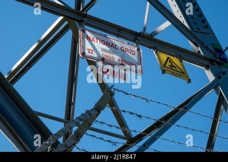 Unterer Abschnitt eines Sendeturms mit Warnschild „Gefahr des Todes“ und kletterfester Stacheldraht-Barriere gegen einen blauen Himmel Stockfoto