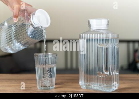 Von Hand sauberes und reines Wasser in ein Glas gießen. Stockfoto