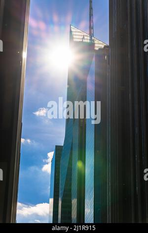 Die Sonne scheint zwischen den Reihen von Hochhäusern in Midtown Manhattan NYC. Stockfoto