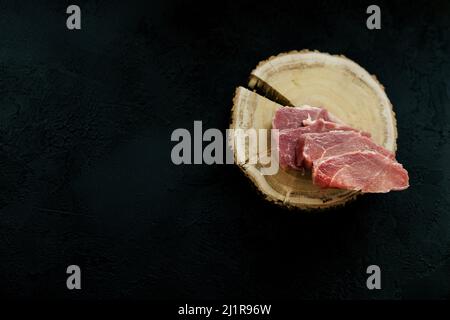 Draufsicht rohes Schweinekotelett Steak auf Holzhintergrund. Rustikaler Stil. Copy space Stockfoto