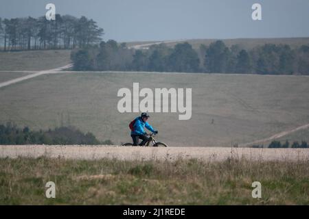 Ein Gelegenheitsradler auf einem Steinweg, der die salisbury-Ebene, Wiltshire, Großbritannien, überquert Stockfoto