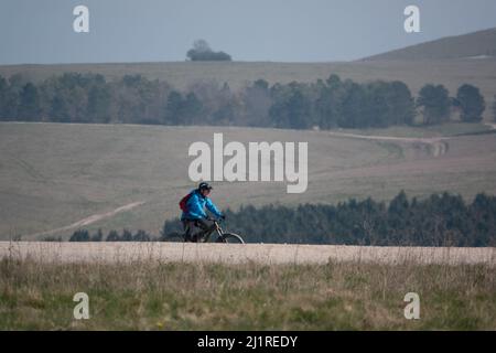 Ein Gelegenheitsradler auf einem Steinweg, der die salisbury-Ebene, Wiltshire, Großbritannien, überquert Stockfoto