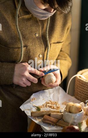 Weibliche Schnitzer arbeiten Schnitzerei Holz tragen Gesichtsmaske. Mädchen Zimmermann Herstellung von Holzfiguren im Studio Stockfoto