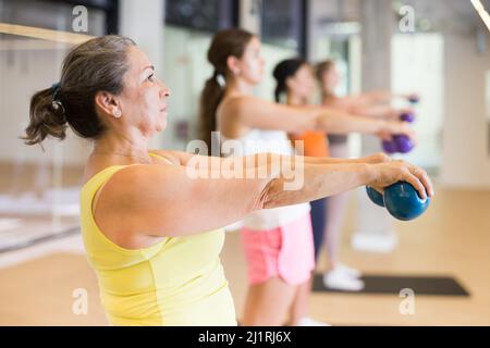 Reife weibliche Durchführung Satz von Übungen mit Pilates Ball Stockfoto