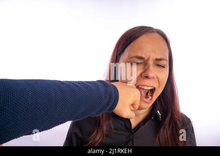 Der Mann schlug das Weibchen. Die Faust eines Mannes trifft eine Frau ins Gesicht. Zwischenmenschliche Konflikte und Gewalt in der Familie. Stockfoto