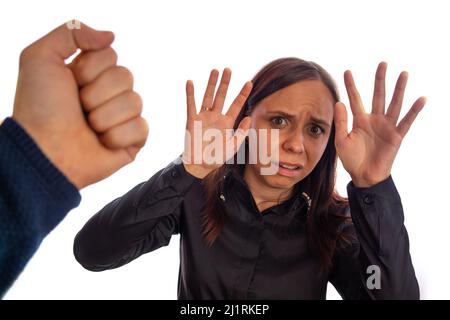 Der Mann schlug das Weibchen. Die Faust eines Mannes trifft eine Frau ins Gesicht. Zwischenmenschliche Konflikte und Gewalt in der Familie. Stockfoto