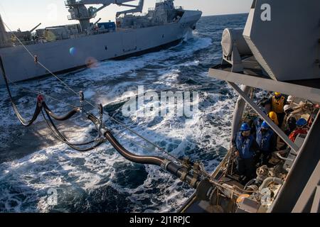 NORTH SEA (15. März 2022) Seeleute an Bord des Arleigh Burke-Klasse Lenkraketen-Zerstörers USS Roosevelt (DDG 80) tanken das Schiff während einer Nachfüllung auf See mit dem Royal Norwegian Navy Nachschubtanker HNoMS Maud (A530), 15. März 2022. Roosevelt, der im spanischen Rota stationiert ist, befindet sich auf seiner dritten Patrouille im Einsatzgebiet der Sechsten US-Flotte zur Unterstützung regionaler Bündnispartner und Partner sowie der nationalen Sicherheitsinteressen der USA in Europa und Afrika. (USA Navy Foto von Mass Communication Specialist 2. Class Andrea Rumple/veröffentlicht) Stockfoto