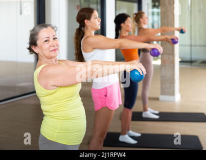 Reife weibliche Durchführung Satz von Übungen mit Pilates Ball Stockfoto