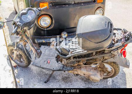 Alte schwarze gebrochen schmutzigen VW-Bus Volkswagen Auto rosten und gebrochen Motorroller am Straßenrand in Playa del Carmen Quintana Roo Mexiko. Stockfoto