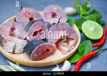 Schlangenkopf-Fisch zum Kochen, gestreifter Schlangenkopf-Fisch, gehackt mit Zutaten Zitrone auf Holzplatte und Tischküche Hintergrund, frischer roher Snake h Stockfoto