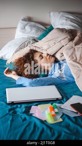 Das lockige Mädchen, das heute Morgen Online-Unterricht nahm, schlief ein. Moderne Online-Bildung. Mädchen studiert online. Online-Bildung, Kurse Stockfoto