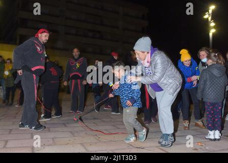 Vendrell, Spanien. 05. Januar 2022. Die Tourismusrätin des Stadtrates von Vendrell, Barbara Peris, hilft einem ukrainischen Flüchtlingskind, mit einem Feuerwerkskörper zu spielen. Die Vereinigung „DRAC de FOC El Cabrot de El Vendrell“ (Feuerdrache) handelt in einer pyrotechnischen Darstellung in Solidarität und Unterstützung für Menschen ukrainischer Nationalität, die aufgrund der Invasion Russlands in der Ukraine in Hotels und kommunalen Hostels in der Stadt Vendrell Flüchtlinge sind, Die Aufführung von Feuerparaden ist eine katalanische Tradition, die jedes Jahr in Städten und Gemeinden stattfindet. Kredit: SOPA Images Limited/Alamy Live Nachrichten Stockfoto