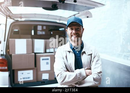 Alles verpackt und bereit zur Lieferung. Porträt eines fröhlichen jungen gebliebenen Mannes, der neben einem Lieferwagen voller Kisten steht und die Arme nach außen gefaltet sind Stockfoto