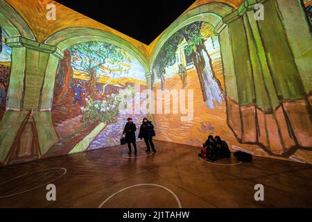 Toronto, Kanada. 26. März 2022. Zwei Menschen sahen sich eine immersive Kunstausstellung an. Die Ausstellung Immersive Van Gogh ist dem Werk des Malers Vincent Van Gogh in Toronto, Kanada, gewidmet. Die Umwandlung eines 5-stöckigen, 600.000 Kubikfuß großen Lagerhauses in eine beleuchtete digitale Galerie umfasst derzeit über 18 ähnliche Ausstellungen in ganz Nordamerika. Kredit: SOPA Images Limited/Alamy Live Nachrichten Stockfoto