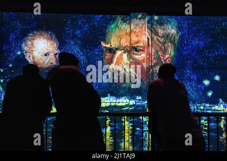 Toronto, Kanada. 26. März 2022. Die Menschen stehen vor einer immersiven Kunstausstellung mit Porträts von Van Gogh. Die Ausstellung Immersive Van Gogh ist dem Werk des Malers Vincent Van Gogh in Toronto, Kanada, gewidmet. Die Umwandlung eines 5-stöckigen, 600.000 Kubikfuß großen Lagerhauses in eine beleuchtete digitale Galerie umfasst derzeit über 18 ähnliche Ausstellungen in ganz Nordamerika. Kredit: SOPA Images Limited/Alamy Live Nachrichten Stockfoto