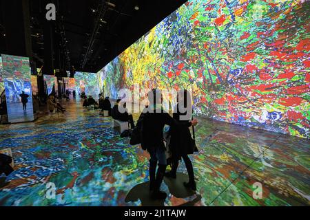 Toronto, Kanada. 26. März 2022. Zwei Menschen sahen in einer immersiven Kunstausstellung chatten. Die Ausstellung Immersive Van Gogh ist dem Werk des Malers Vincent Van Gogh in Toronto, Kanada, gewidmet. Die Umwandlung eines 5-stöckigen, 600.000 Kubikfuß großen Lagerhauses in eine beleuchtete digitale Galerie umfasst derzeit über 18 ähnliche Ausstellungen in ganz Nordamerika. Kredit: SOPA Images Limited/Alamy Live Nachrichten Stockfoto