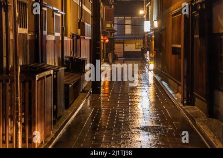 Holzgebäude säumen die nasse Gasse im historischen Kyoto-Viertel Stockfoto