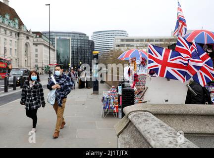 London, Großbritannien. 27. März 2022. Maskierte Menschen gehen auf einer Straße in London, Großbritannien, 27. März 2022. Kredit: Li Ying/Xinhua/Alamy Live Nachrichten Stockfoto