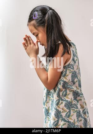 Portrait Asian Kind Mädchen ist Gruß in Thailand traditionellen Stil, der Sawatdee genannt. Asiatischer Grußstil von Hand zusammengestellt. Kind Mädchen mit 7 Jahren Stockfoto