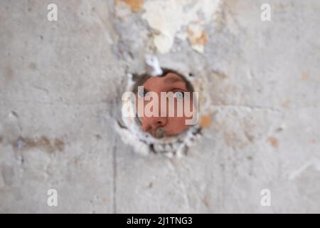 Zerbrochenes Zementwandfoto mit Abschneideweg des Lochs. Stockfoto