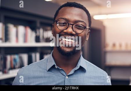 Vertrauen Sie mir, dass ich alle Entwürfe perfekt mache. Ein Porträt eines hübschen jungen Architekten, der lächelt, während er in einem modernen Büro steht. Stockfoto