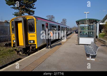 Der Zugfahrer bereitet sich darauf vor, am Wrexham General Railway Station in das Taxi seines DMU-Zuges Transport for Wales Class 150 zu steigen Stockfoto