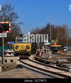 Colas Rails Diesellokomotive 70813 überquert den gerade erneuerten Bahnübergang Strand Road in Preston mit einem Zug leerer Öltankschiffe. Stockfoto