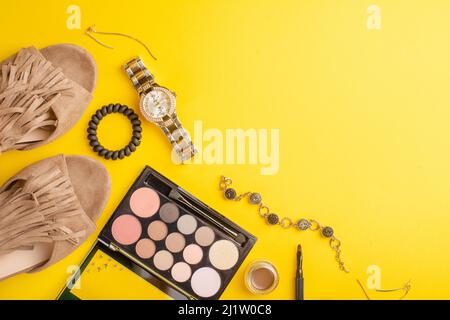 Beauty-Konzept in einem Blog. Professionelle weibliche Make-up Accessoires, Uhr, Armband, Lippenstift, Puder, Auf gelbem Hintergrund. Weiblicher Hintergrund und fa Stockfoto