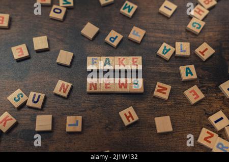 FAKE NEWS - eine Phrase aus Holzblöcken mit Buchstaben Social-Media-Konzept. Hochwertige Fotos Stockfoto