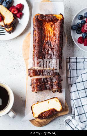 Hausgemachter rechteckiger San Sebastian gebrannter Käsekuchen mit Beeren zum Frühstück, Draufsicht. Stockfoto