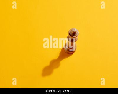 Queen-Schachfigur auf gelbem Hintergrund mit Kopierplatz. Stockfoto