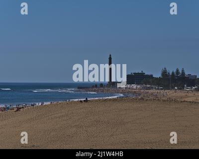 Luftaufnahme über den überfüllten Strand Playa de Maspalomas mit Sanddüne vor dem Strand und Leuchtturm Faro de Maspalomas im Süden von Gran Canaria, Spanien. Stockfoto