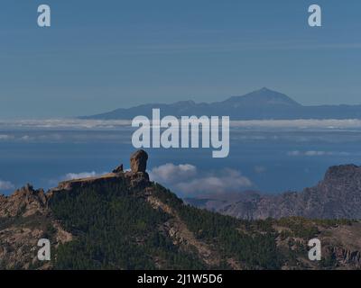 Blick auf die Felsformation Roque Nublo in den zentralen Bergen von Gran Canaria, Spanien Blick vom Pico de las Nieves mit der Insel Teneriffa und dem Teide. Stockfoto