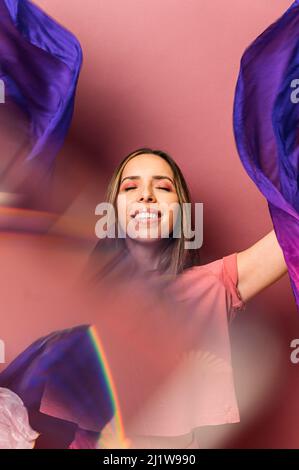 Weibliche hispanische Tänzerin, die traditionellen East Dance mit strahlend winkenden Fans im Studio tanzt Stockfoto