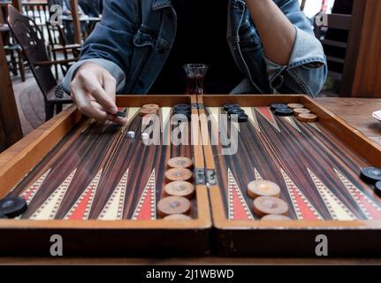 Nahaufnahme Frau Hand hält Backgammon Würfel und spielt Backgammon draußen. Der Fokus liegt auf ihrer Hand. Stockfoto