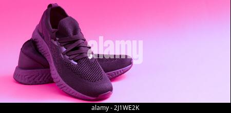 Sneakers-Konzept mit Platz für Text. Nahaufnahme von rosa Sneakers auf hellem Hintergrund. Sportschuhe für Laufen und Fitness. Paar Schuhe. Aktiver Lebensstil. Textur mit lila Sohle und Schnürsenkeln. Stockfoto