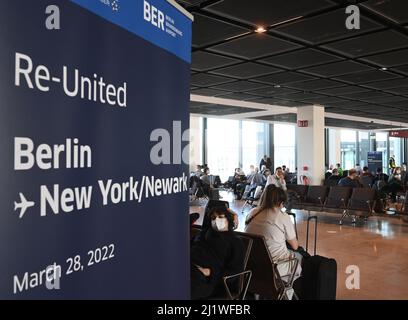 28. März 2022, Brandenburg, Schönefeld: Passagiere warten am Flugsteig am Flughafen BER auf den Abflug des Fluges der United Airlines nach New York/Newark. Auf Flügen an die US-Ostküste müssen Berliner und Brandenburger nicht mehr unbedingt das Flugzeug wechseln. Ab Montag verbindet United Airlines Schönefeld täglich direkt mit dem New Yorker Flughafen Newark. Dies ist die erste Langstreckenverbindung vom BER in die USA. Foto: Bernd Settnik/dpa-Zentralbild/dpa Stockfoto