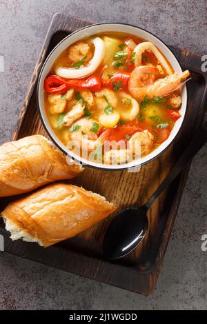 Caldeirada Portugiesische Meeresfrüchte Eintopf mit Garnelen, Muscheln und Tintenfisch in der Schüssel auf dem Tisch. Vertikale Draufsicht von oben Stockfoto