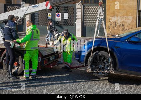 Neapel, Italien - 25. März 2022: Entfernung mit dem Abschleppwagen eines geparkten Autos ohne Parkplatz. Städtische Polizeibeamte verhängten eine Geldstrafe und befahlen die Entfernung eines Stockfoto