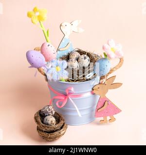 Ostern Kinder Dekorationen Idee. Interieur Urlaub Zusammensetzung mit kleinen Eimer mit Nestern von Wachteleiern, dekorative Eier, Blumen, Hasen. Pastell p Stockfoto