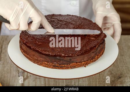 Konditor, der Schokolade-Nuss-Creme macht, verwendet Spatel Stockfoto